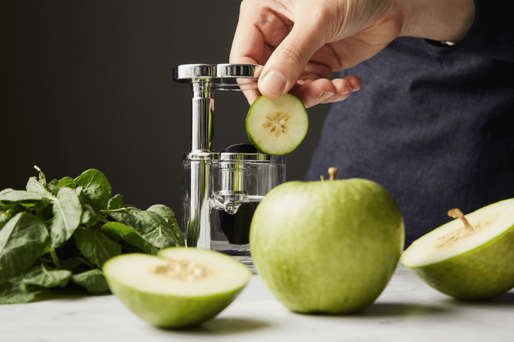 Preparing Green juice by feeding fresh ingredients into a juicer